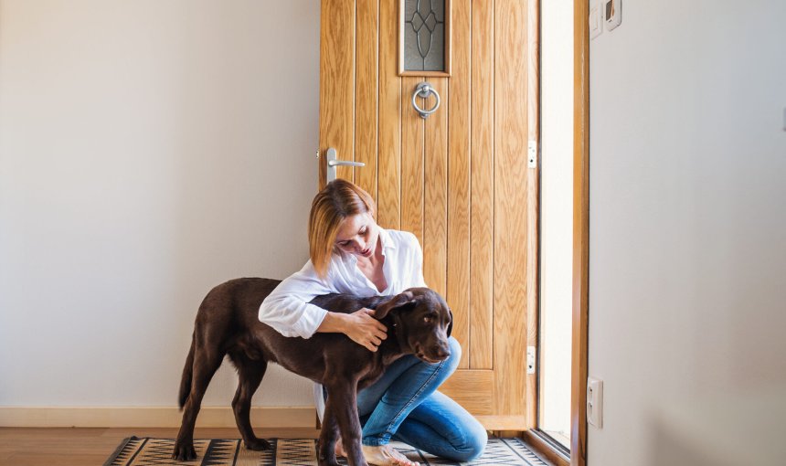 A woman comforting a dog with separation anxiety