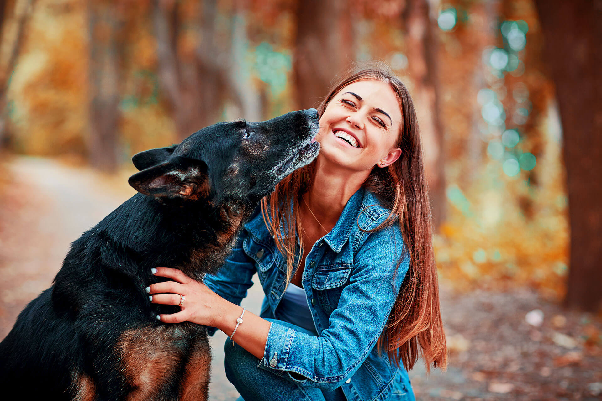 A woman hugging a black dog