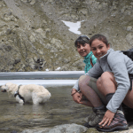 Tractive pet parents Francesca sitting by a lake with her dog, Happy.