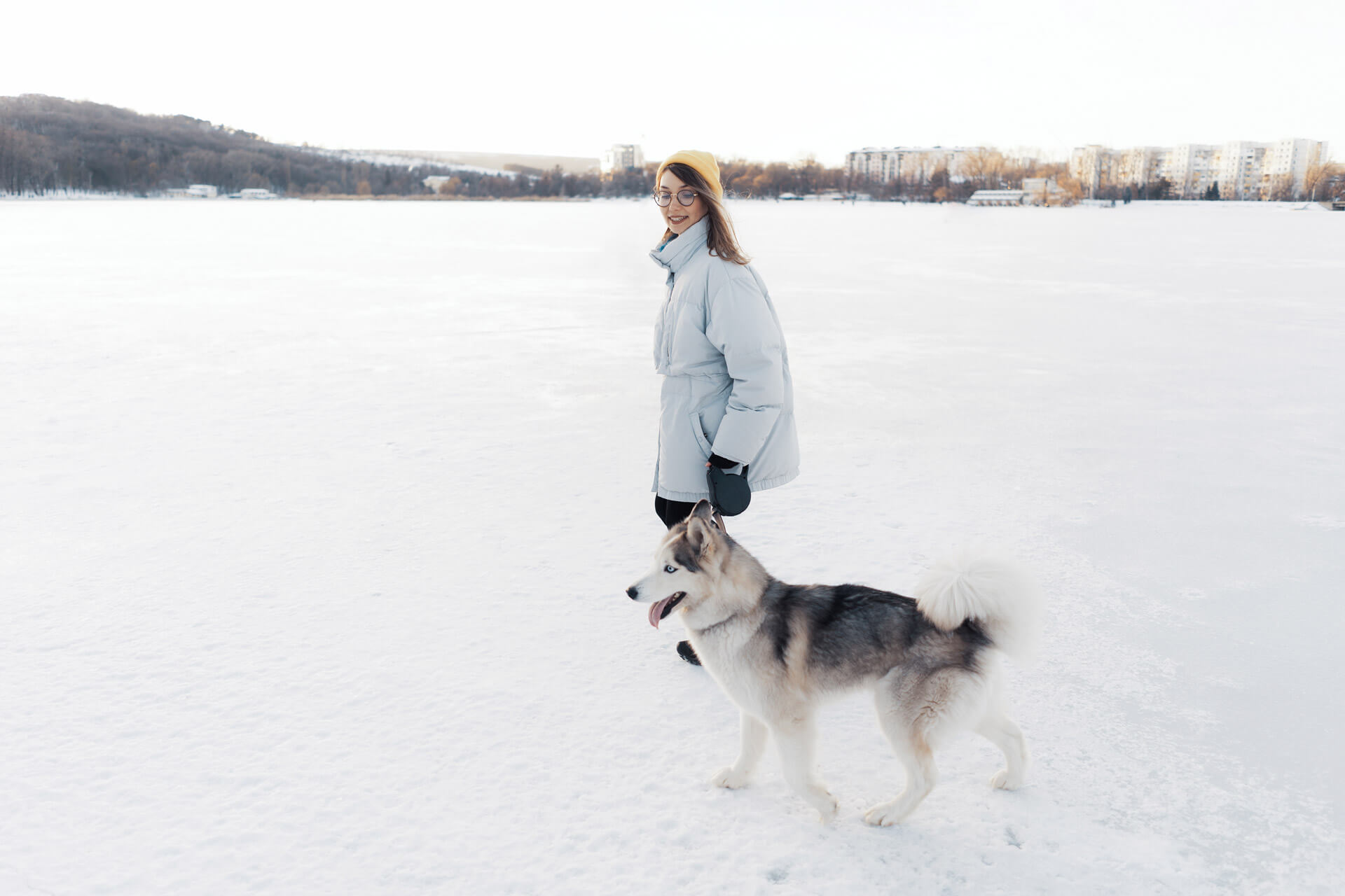 Frau beim Spaziergang mit Hund in Winterlandschaft