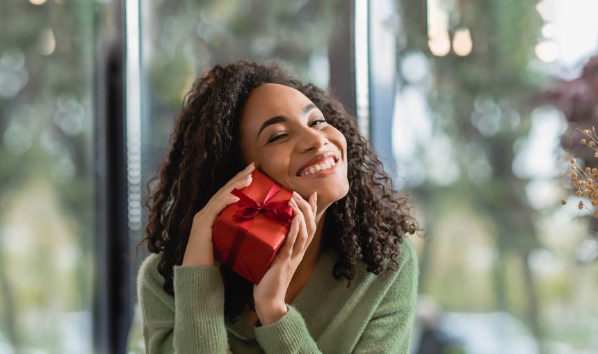 woman holding small red gift-wrapped present