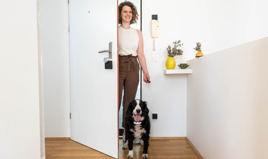 Frau mit Hund öffnet Tür mit Smart Lock