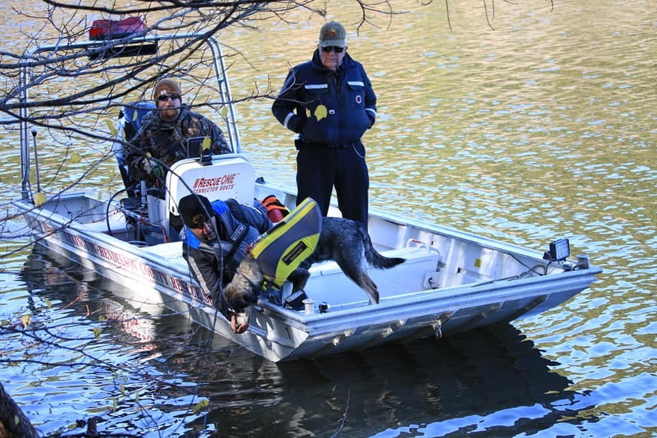 search dog and people on a boat during search and rescue mission 