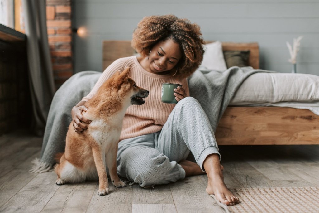 A woman enjoying a cup of tea with her dog before bedtime