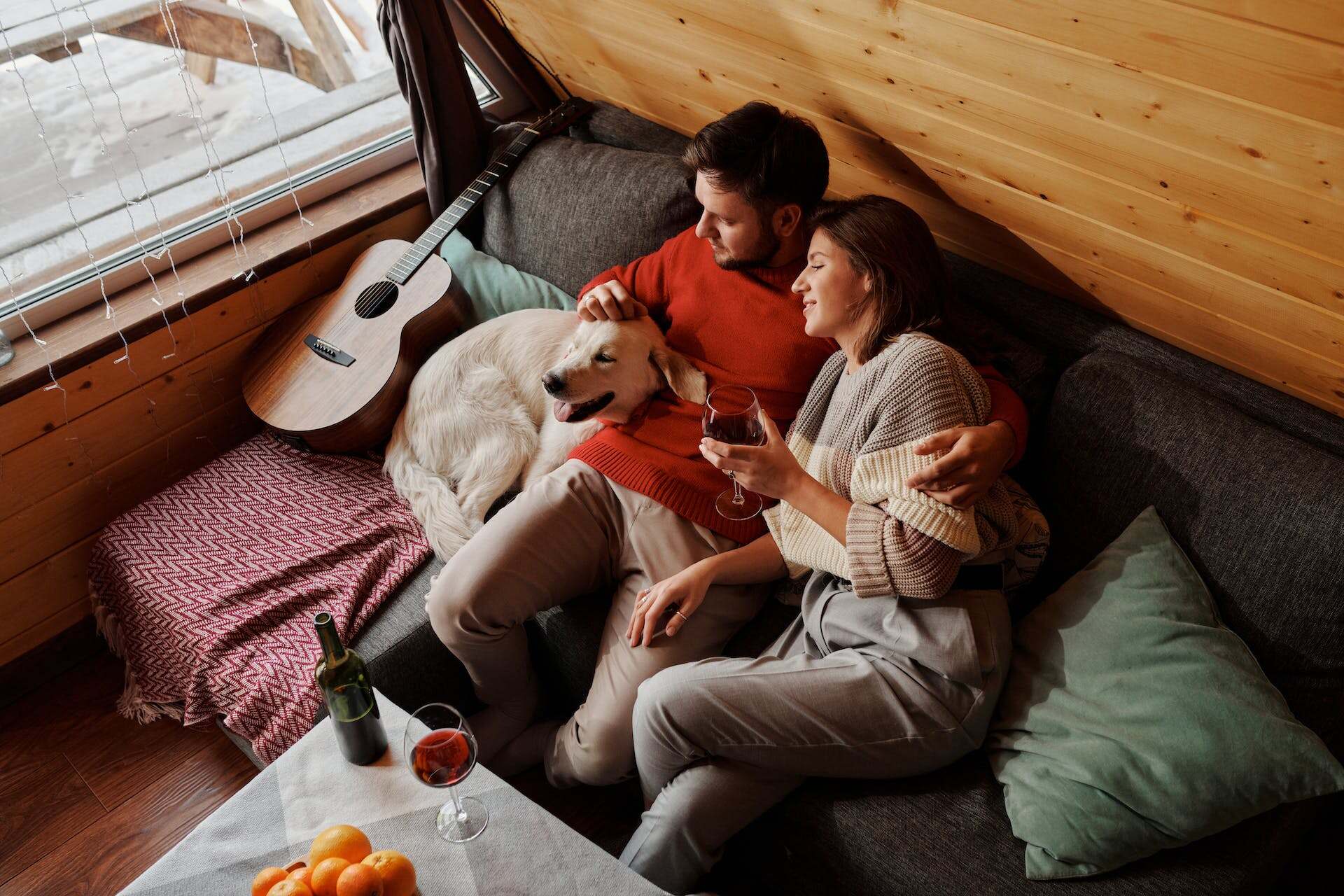 A couple enjoying a glass of wine next to their dog