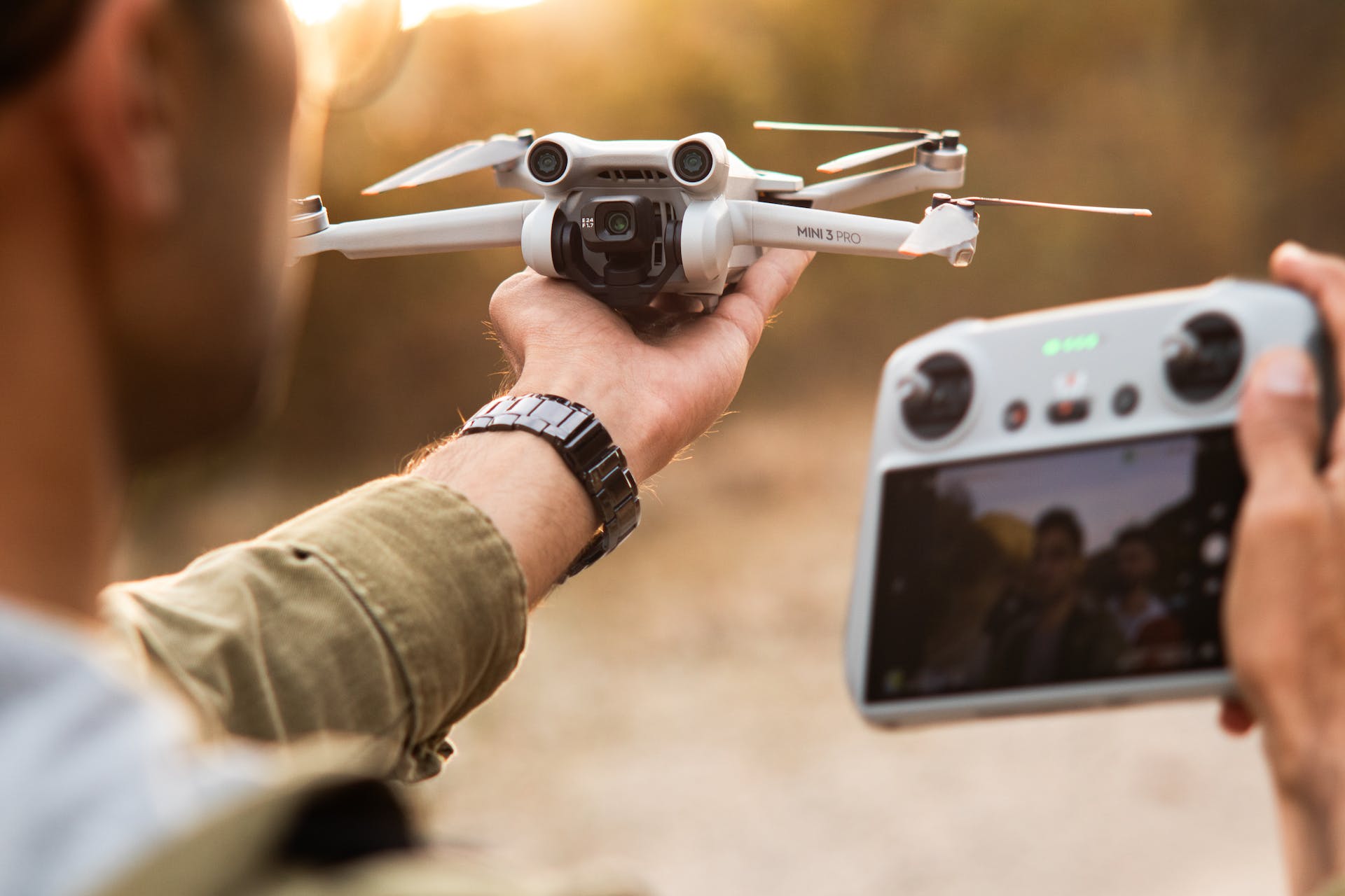 A man holding up a drone and tracking device