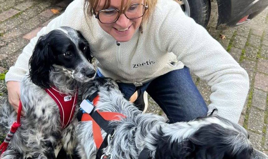 A woman hugging two rescued Setters that are wearing Tractive GPS trackers