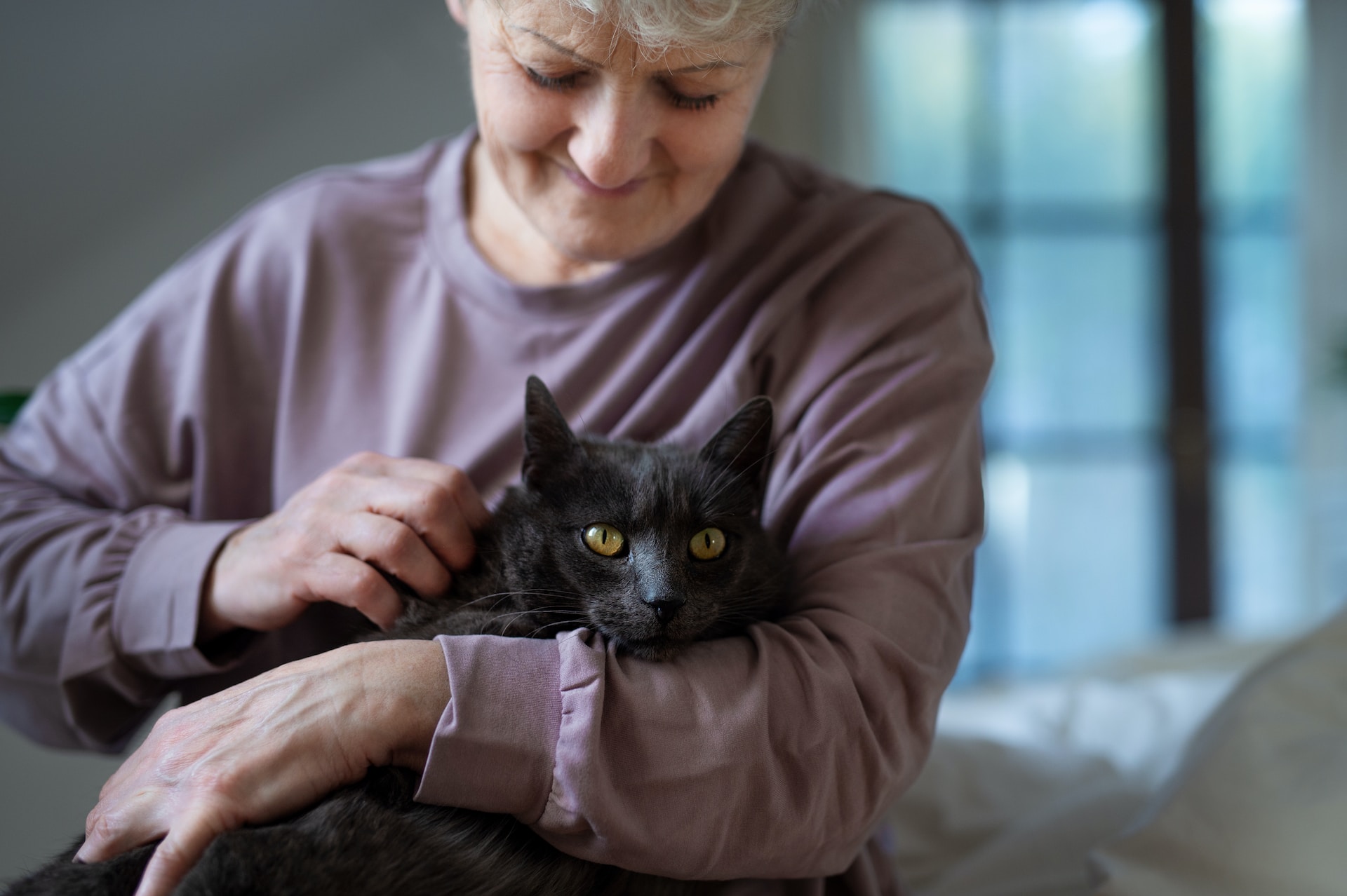 Frau hält ihre schwarze Katze im Arm