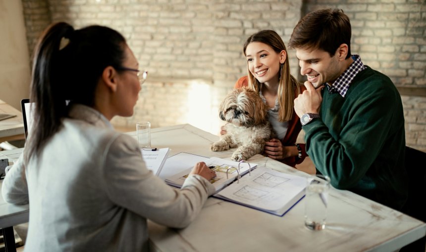 A young couple discussing pet insurance plans with an agent