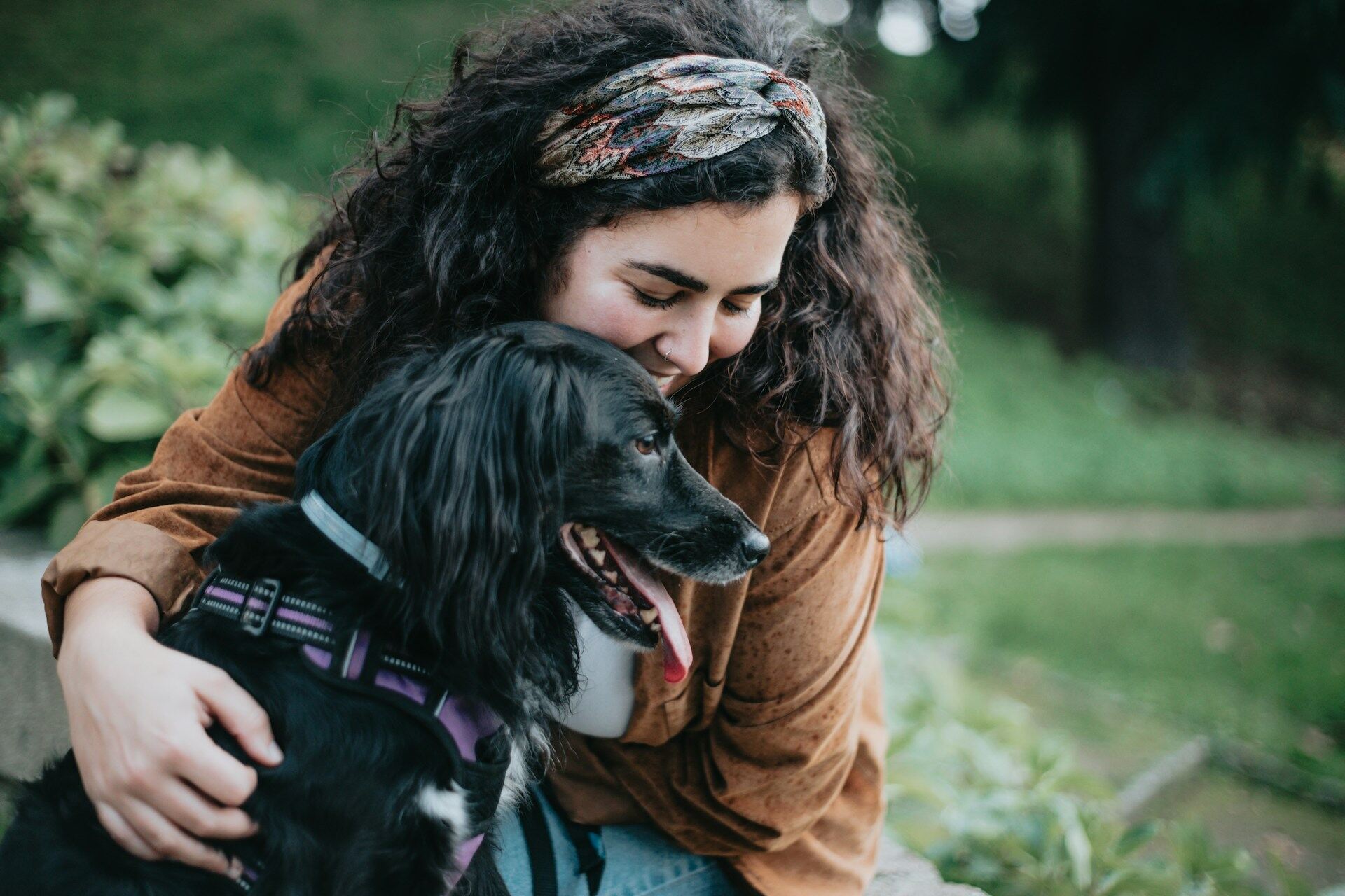 A woman hugging her dog outdoors