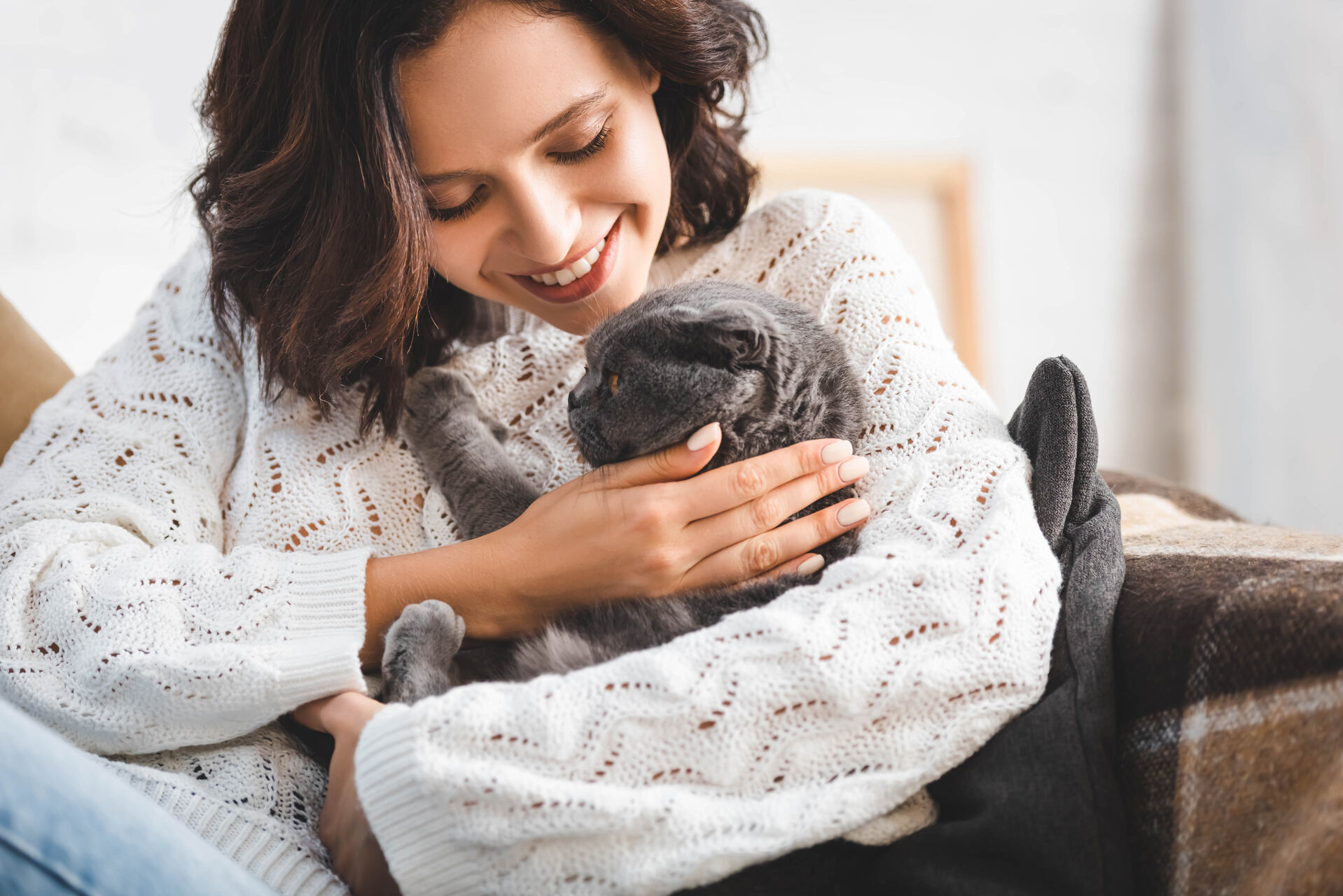 A woman cuddling with a cat indoors