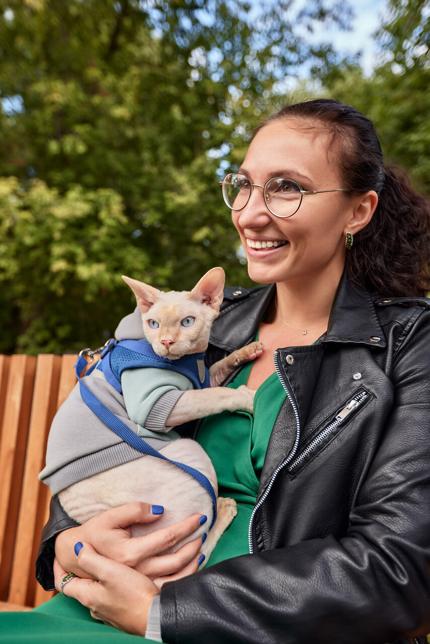 A woman sitting with a cat outdoors