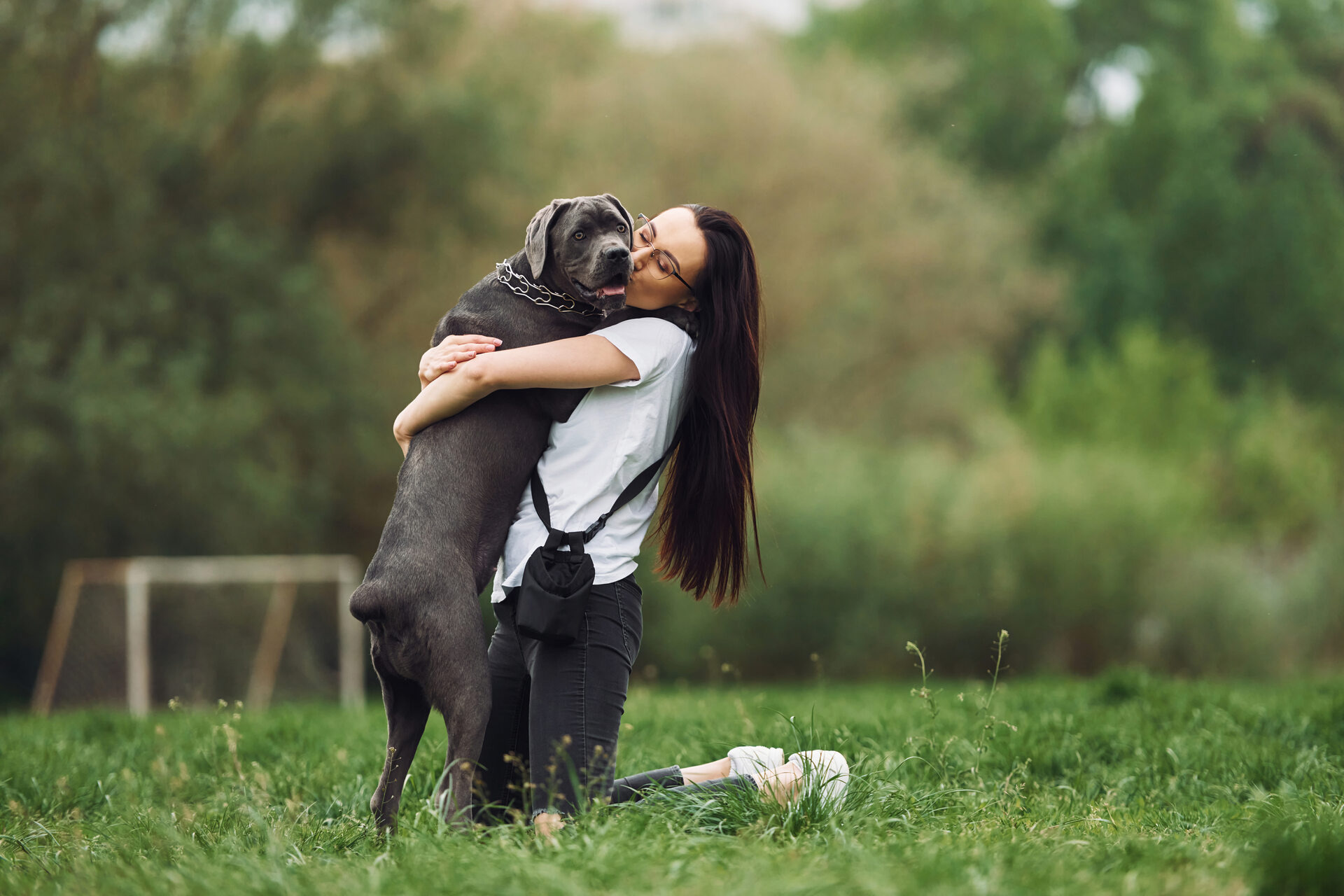 A woman hugging her dog in a garden