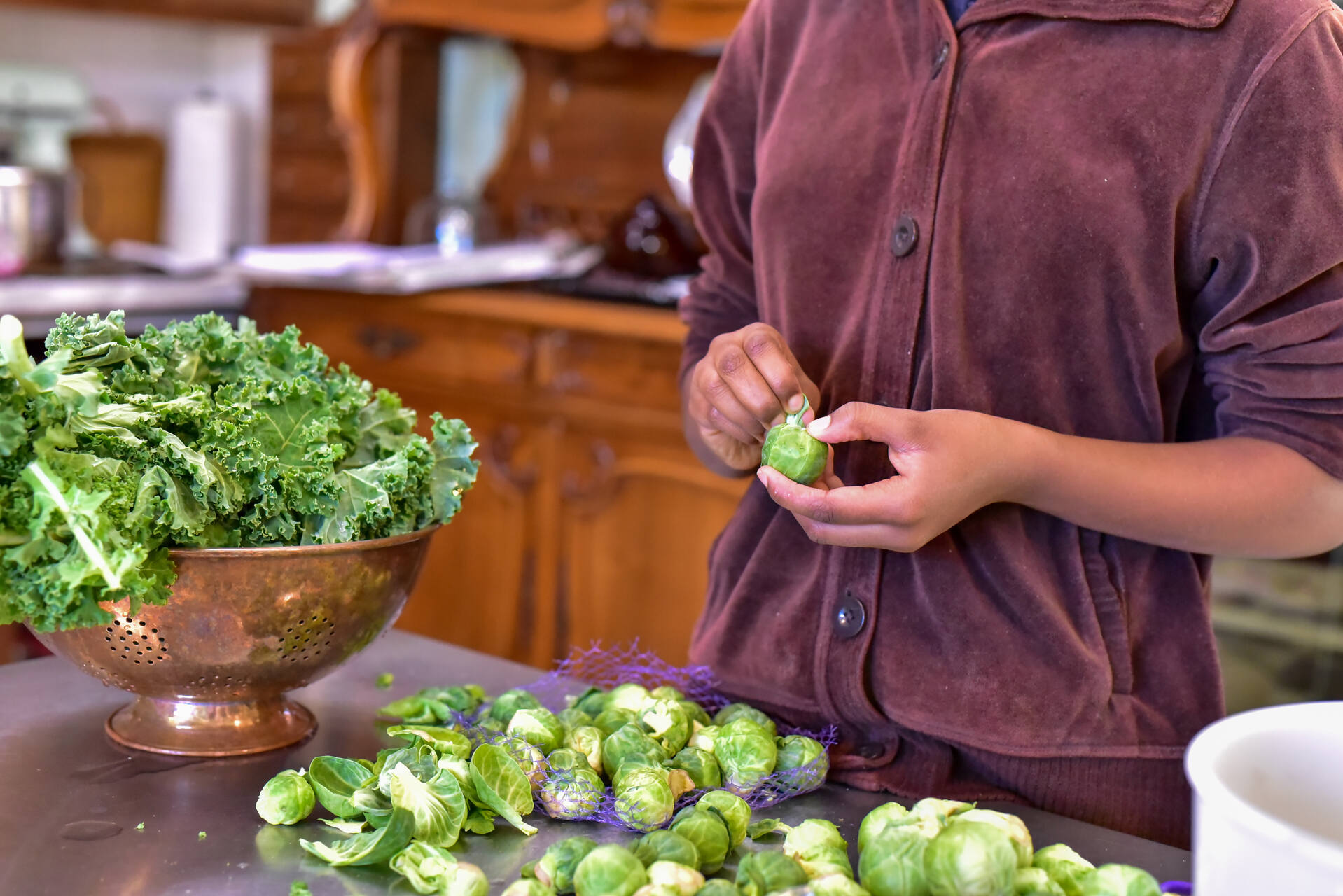 A man preparing brussel sprouts in a kitchen