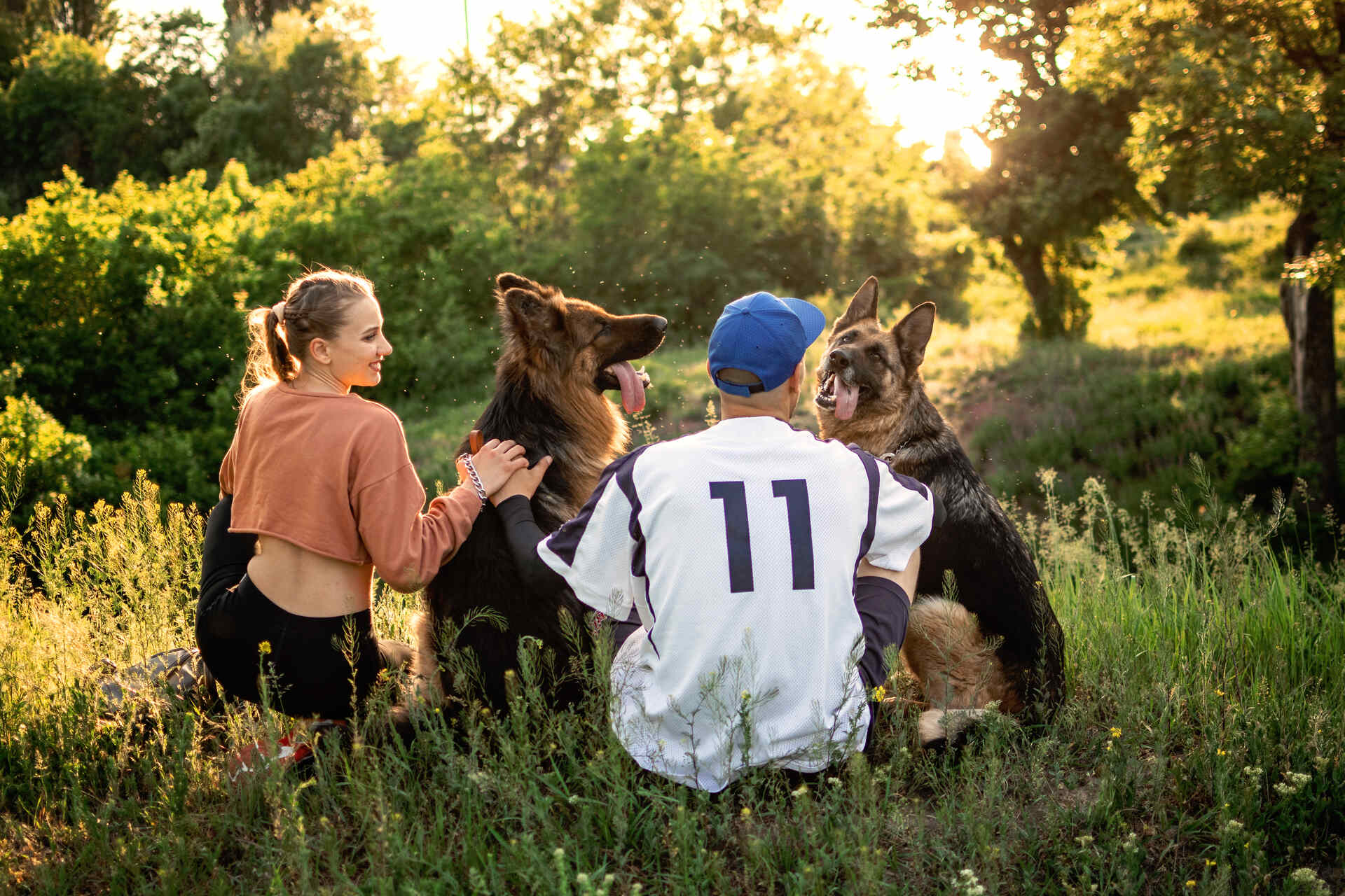 A couple outdoors with a pair of German Shepherds