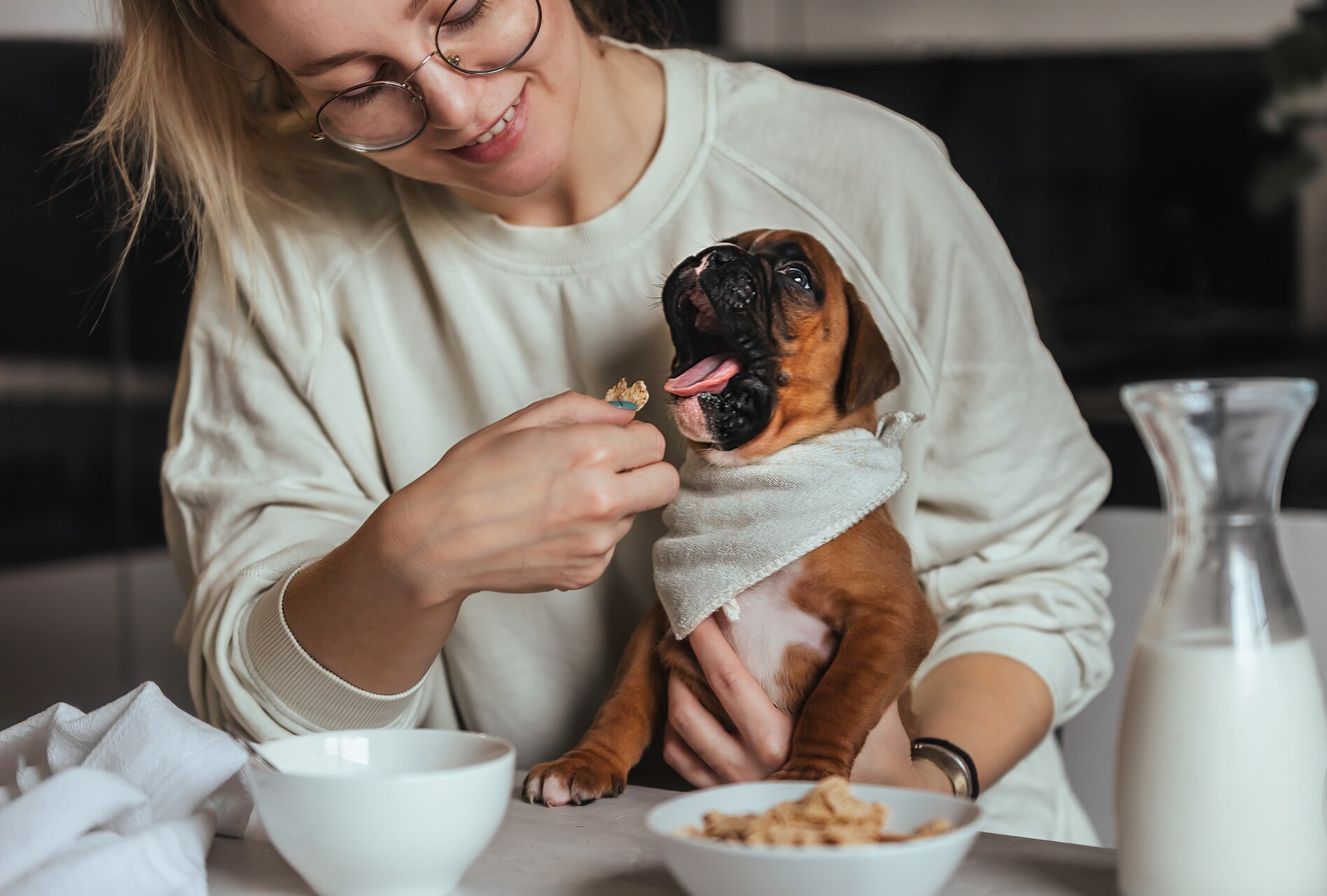 A woman feeding a puppy