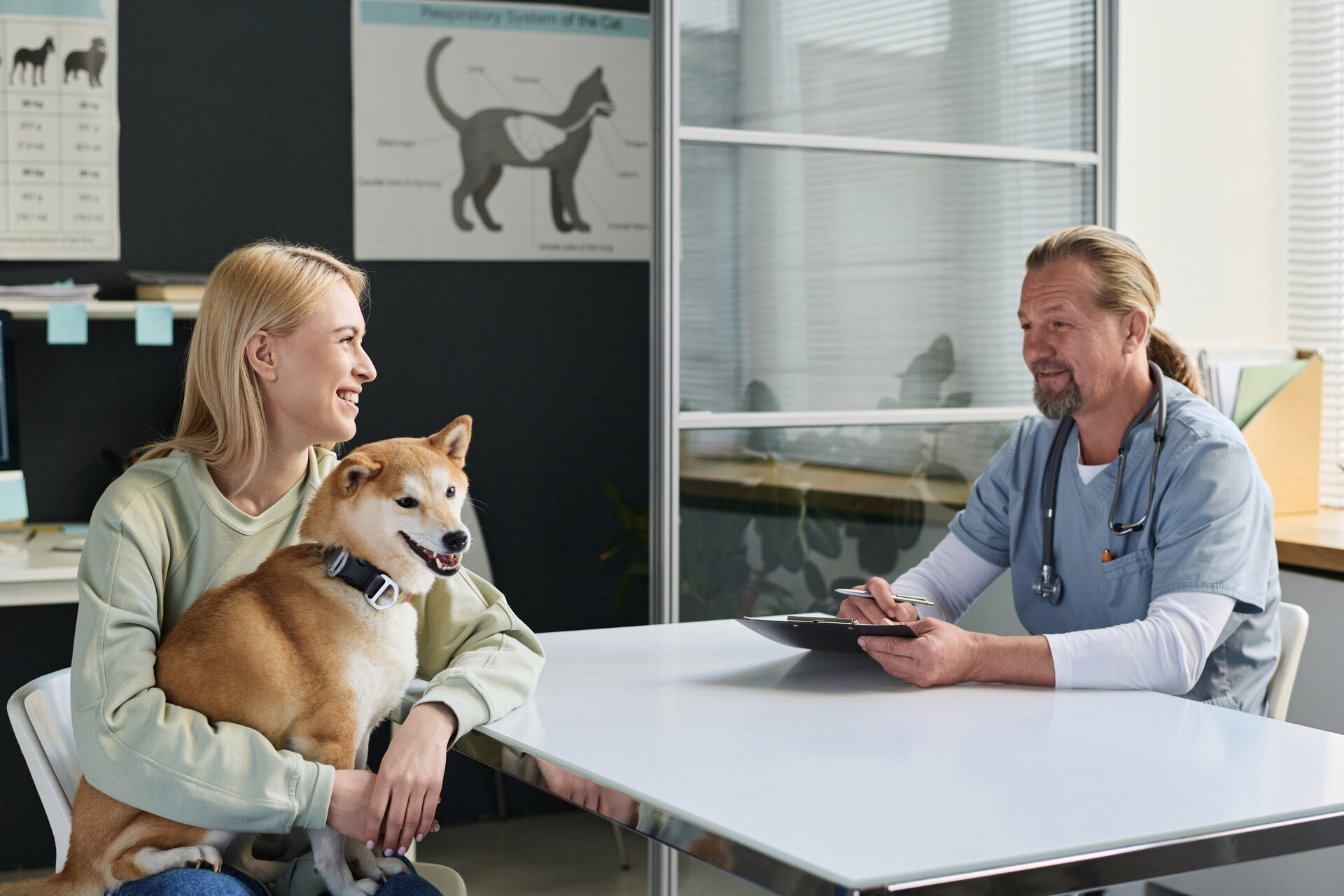 A woman discussing taking a dog first aid course with her vet