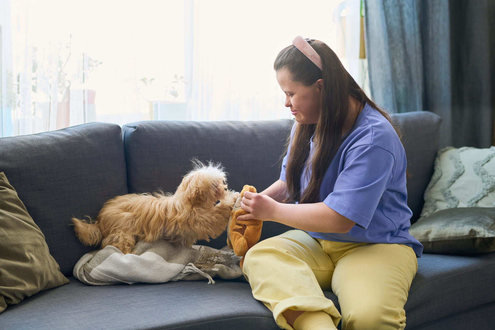 A pet sitter checking in on a puppy at home