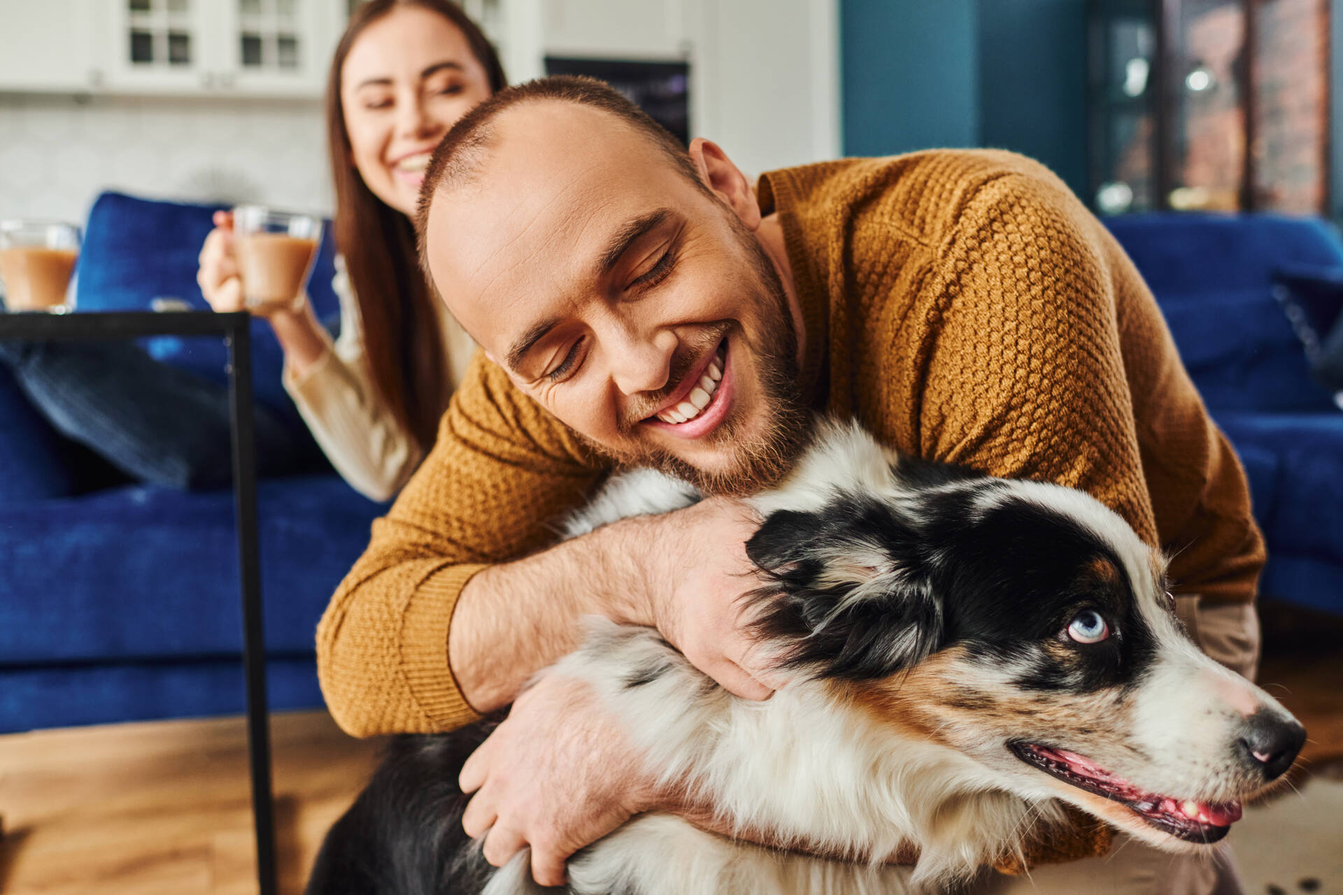 A man hugging a dog indoors