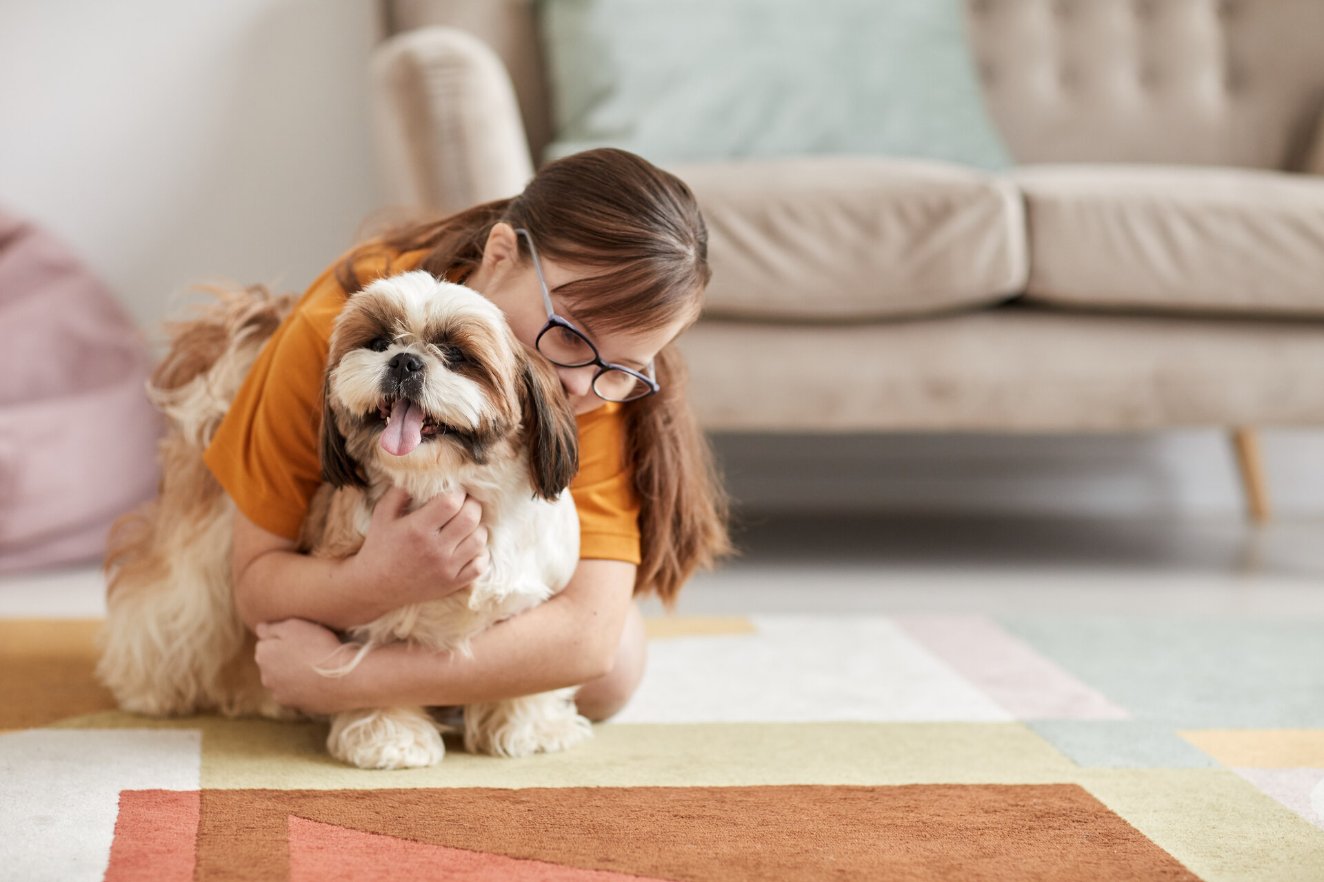 A girl playing with a dog indoors