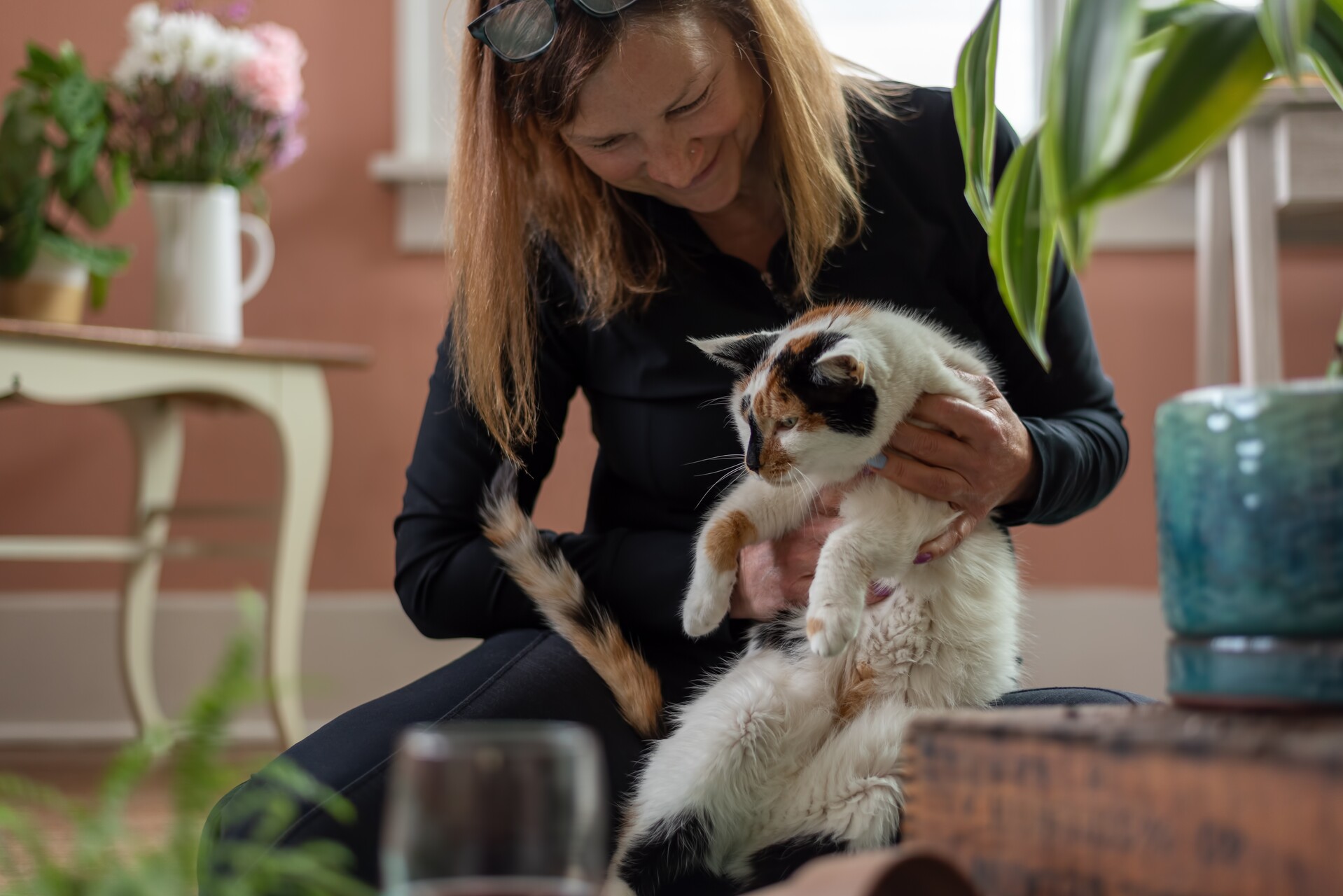 A woman playing with a cat indoors