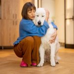 A woman hugging her anxious dog indoors