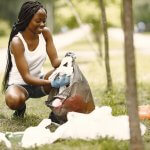 A woman picking up trash at a park