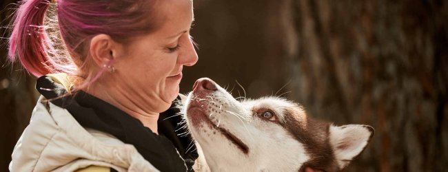 A woman hugging a Husky dog