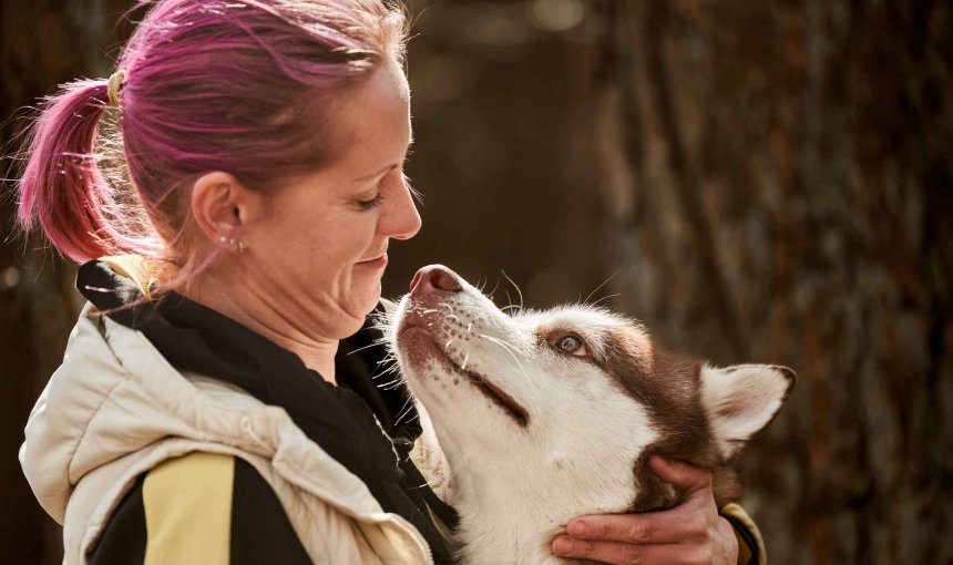 A woman hugging a Husky dog