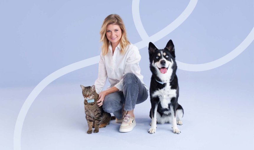 Sandrine Arcizet poses with a cat and dog wearing Tractive GPS trackers.